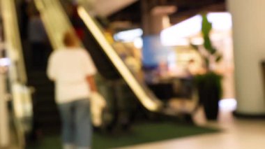 Müşteriler Bangkok 'taki kalabalık alışveriş merkezinde yürüyen merdivenlere çıkıyorlar