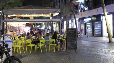 İnsanlar sokak restoranlarında yemek yiyor.