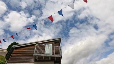 Ahşap bir evin yanında dalgalanan renkli bayraklar