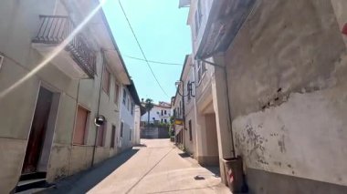 Güneş ışığı ve binalarla dolu sessiz bir ara sokak.