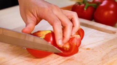 Tahtada bıçakla domates dilimlemek.