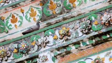 Pigeon perched on ornate temple tiles