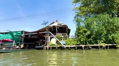 Boat travels along canal near floating market
