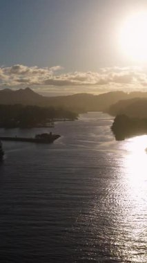 Aerial view of Brunswick River at sunset, capturing serene water reflections and silhouetted landscapes in warm, golden light