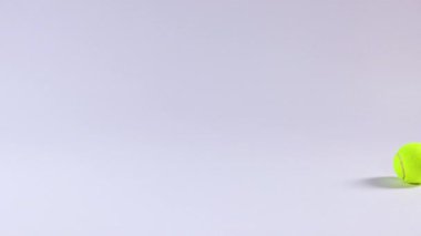 Bir tenis topu düz bir zeminde yuvarlanır.