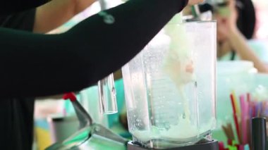 Pouring and blending ingredients for a milkshake