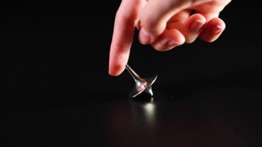 Bir el metalik bir kapağı döndürür.