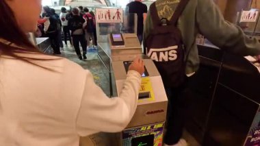 People using tap cards at metro turnstiles