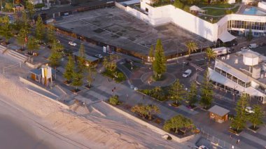 Gün doğumunda Sörfçülerin Cenneti 'nin havadan görünüşü. Sahil şeridini, geçidi ve sabah sıcacık ışıklarıyla çevreleyen mimariyi yakalıyor.