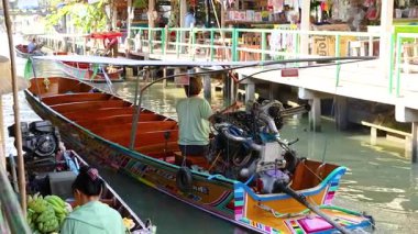 Piyasa kanalında manevra yapan uzun kuyruklu tekne.