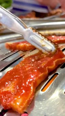 Bangkok 'ta bir mangalda marine edilmiş et ızgarası. Canlı renkler, dinamik kamera açıları, canlı atmosfer.