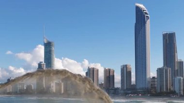 Avustralya, Gold Coast 'taki gökdelenlerin yakınındaki kum taramalarının hava görüntüsü. Açık gökyüzü ve kentsel ufuk çizgisi dinamik bir kıyı manzarası yaratır