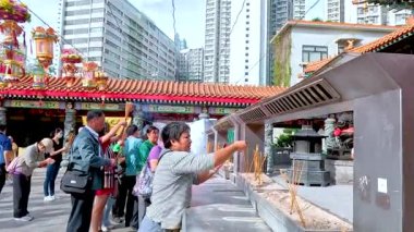 Ziyaretçiler tapınağı keşfeder ve tütsü sunarlar.