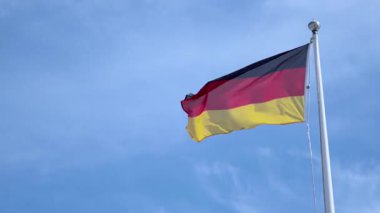 Alman bayrağı açık bir gökyüzüne doğru dalgalanıyor