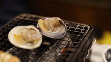 Oysters cooking on a grill, steam rising