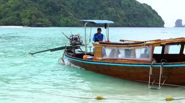 Boat navigating turquoise waters near lush islands