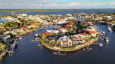 Drone footage captures luxury estates and boats along Gold Coast's waterways under warm, natural lighting