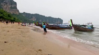 Manzaralı bir sahilde insanlar ve tekneler