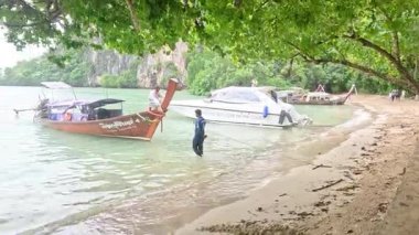 Manzaralı sahili terk eden uzun kuyruklu tekneler.