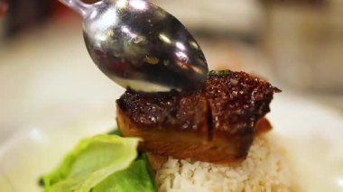 Lezzetli Dong Po pirinçli domuz etinin tadını çıkarıyor.