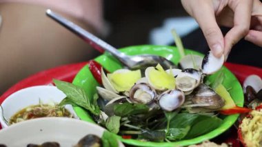 Titrek bir deniz ürünleri tabağında kabuklu deniz ürünleri soyan eller.