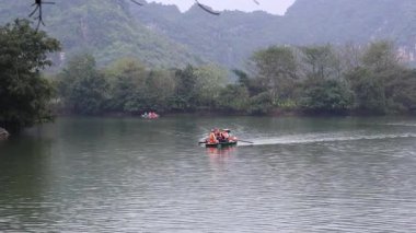 Sakin bir nehirde rafting yapan bir grup insan.