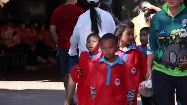 Yetişkinlerle hayvanat bahçesine giden bir grup çocuk.