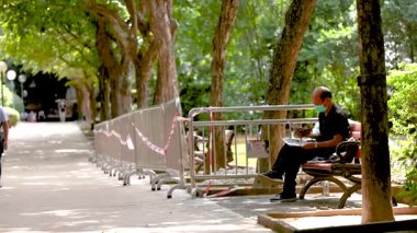 Bir insan parkta sessizce oturur.