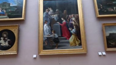 Visitors admire paintings in the Louvre Museum