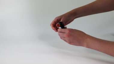 Hands manipulating a small black object
