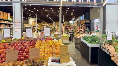 Hareketli bir pazarda renkli ürünler sergileniyor