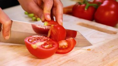 Şef domatesleri ustalıkla dilimler.