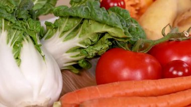 Domates, havuç ve kabak gibi taze sebzelerden oluşan canlı bir karışım. Doğal ışıklandırmada organik ürünler sergileniyor.