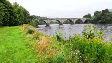 Nehir ve köprüyle huzurlu doğa sahnesi