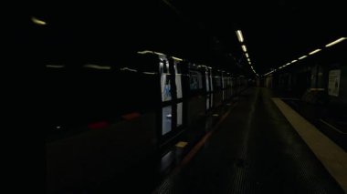 Tren istasyonundan ayrılıyor, yolcular içeride görünüyor.