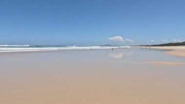 Huzurlu bir plajda gezinen insanlar