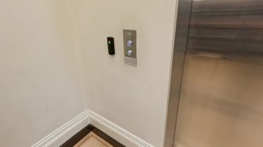 Asansör düğmesi paneliyle etkileşime giren kişi