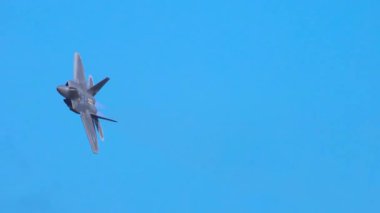 F-22 Raptor açık mavi gökyüzüne karşı dinamik hava manevraları gerçekleştirir, çevikliğini ve hızını 12 saniye içinde gösterir.