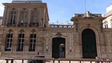 People walking by a historic Parisian building