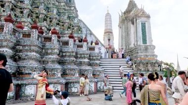 Bangkok 'ta geleneksel Tayland kostümleriyle Wat Arun tapınağını ziyaret eden turistler