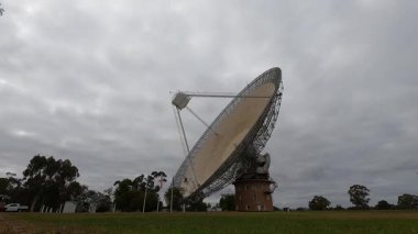 Bulutlu gökyüzünün altında dönen bir uydu anteninin zaman atlaması