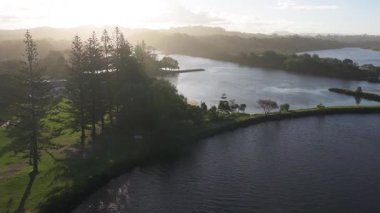 İnsansız hava aracı görüntüleri sakin nehir manzaralarını ve yemyeşil alanları Brunswick Heads, NSW, Avustralya 'da, sakin bir gündoğumu sırasında çeker.