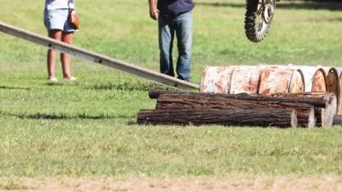 Bir pistte çeşitli engelleri aşan motosikletçi