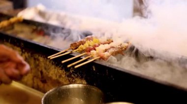 İçerideki dumanlı ızgarada şiş hazırlıyorum.