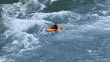 Bir kanocu Queenstown, Yeni Zelanda 'daki Kawarau Nehri' nde akıntıya karşı yüzüyor. Doğal ışıklandırma ile yakalanan dinamik eylem