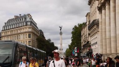 İnsanlar Bordeaux 'daki Girondins Anıtı' nın yanında yürüyorlar.