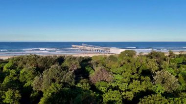 İnsansız hava aracı görüntüleri, Gold Coast Sahili 'nde güneşli bir günü göze çarpan bir iskelede ve yemyeşil bir alanda yakalıyor.