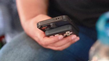 Yüzen bir pazarda akıllı telefon kullanan kişi