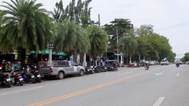 Kalabalık bir cadde boyunca trafik ve dükkanlar