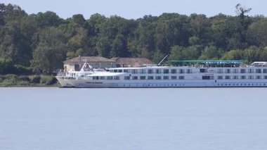 A cruise ship sails along a river